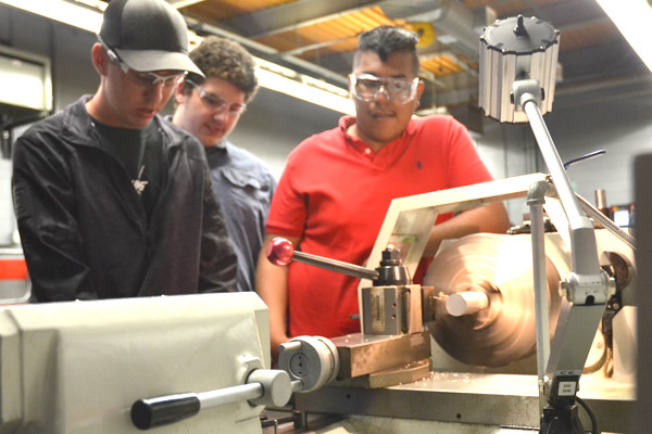 Students working with metal on lathe