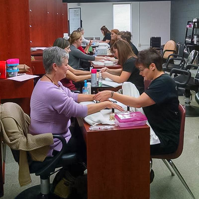 Students performing manicures in the cosmetology lab