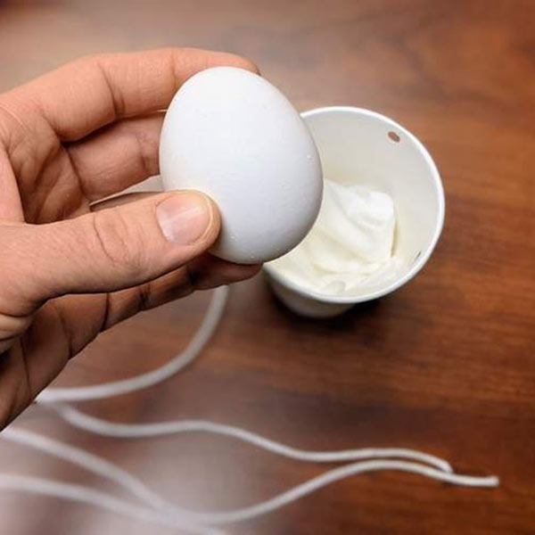 Egg into cup, showing holes across from each other