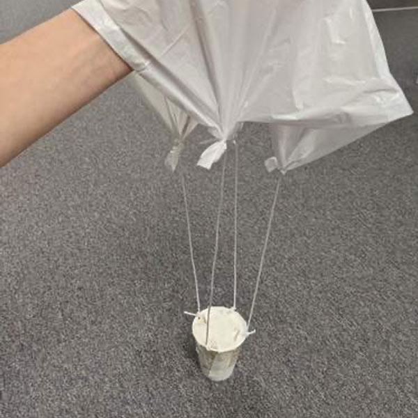 Parachute being held to show how strings are attached to corners of square