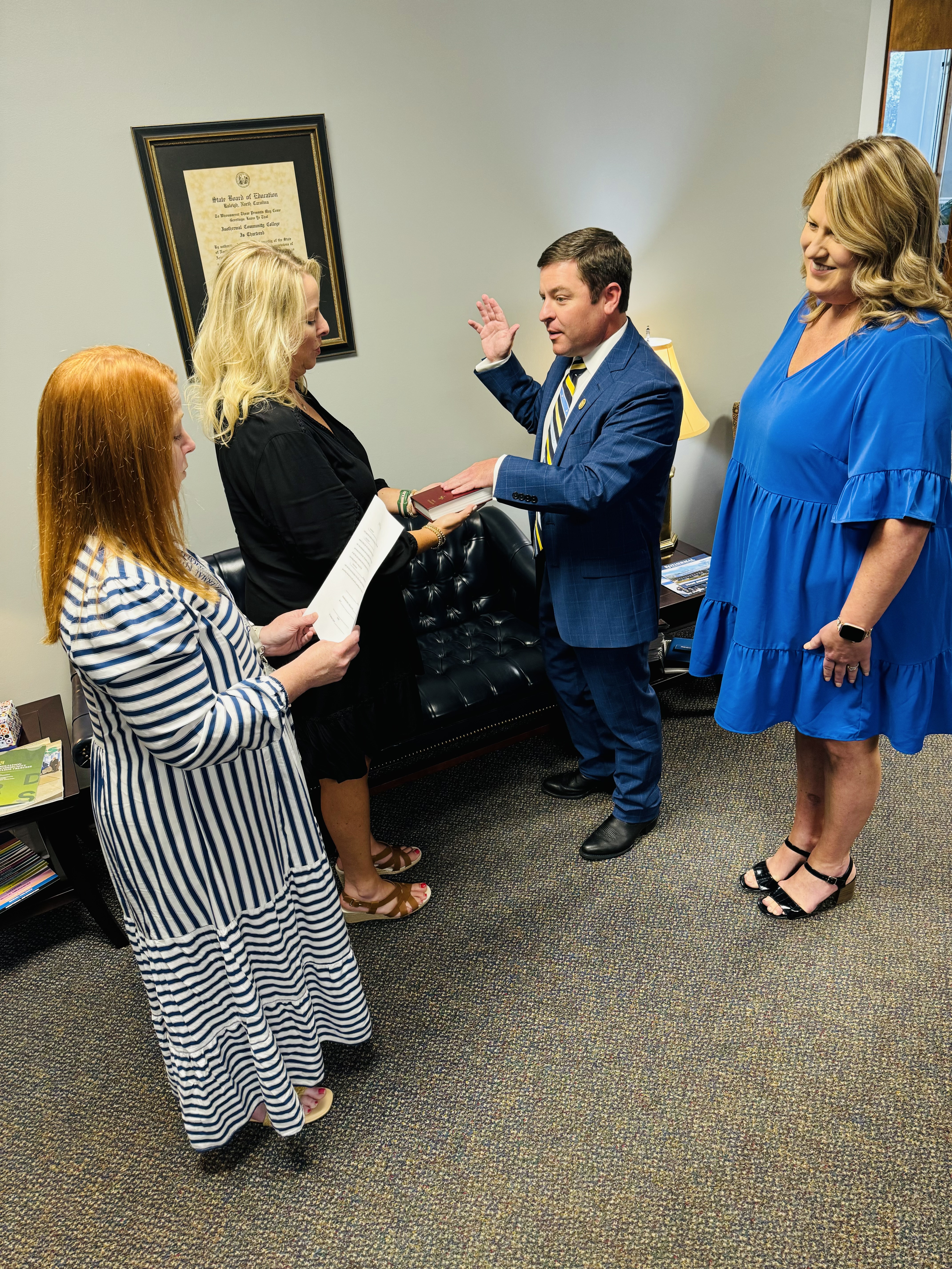 Jordan Barnes is pictured with his hand on a bible being sworn in as a new member of the Isothermal Community College Board of Trustees.