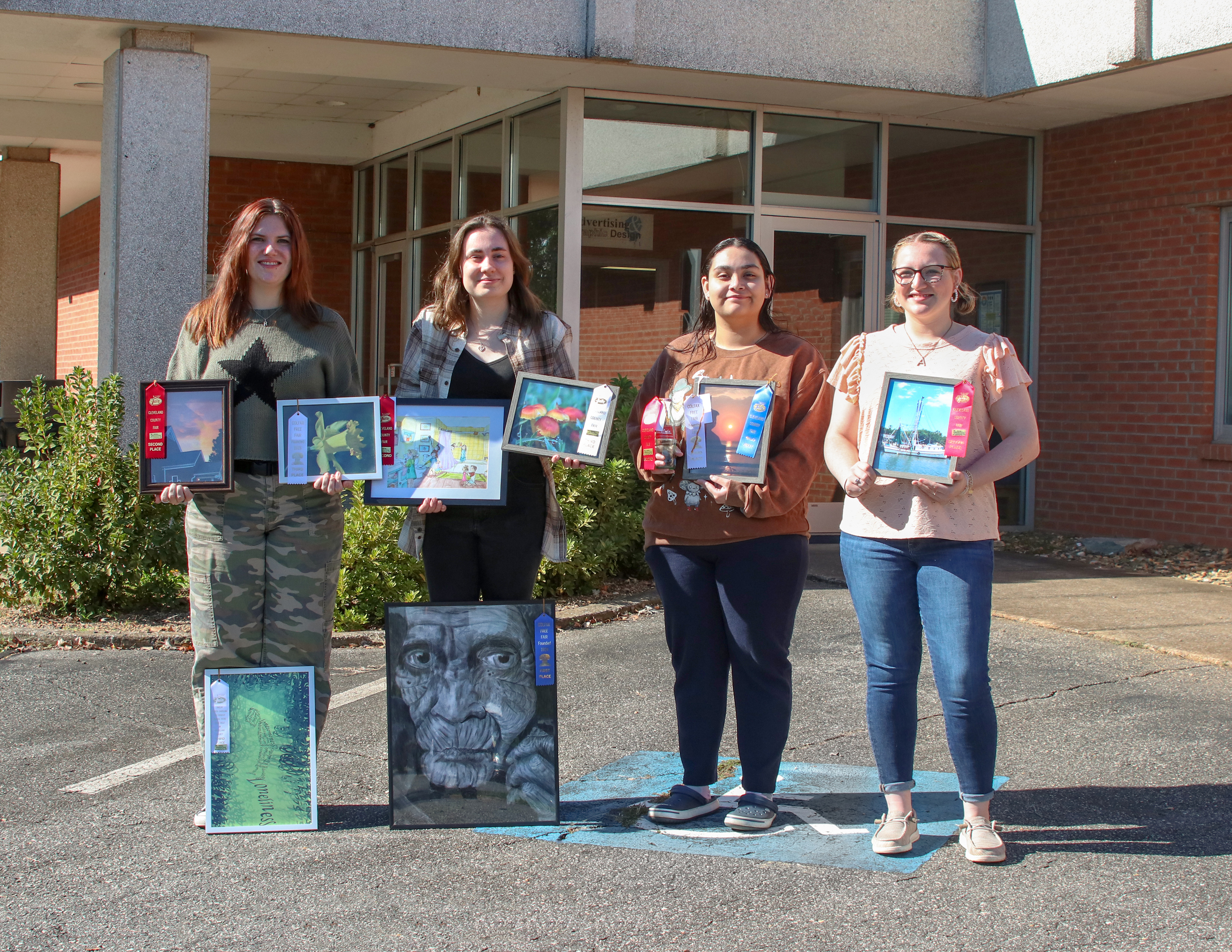 Isothermal Community College students holding their awards from the Colfax and Cleveland County Fairs.