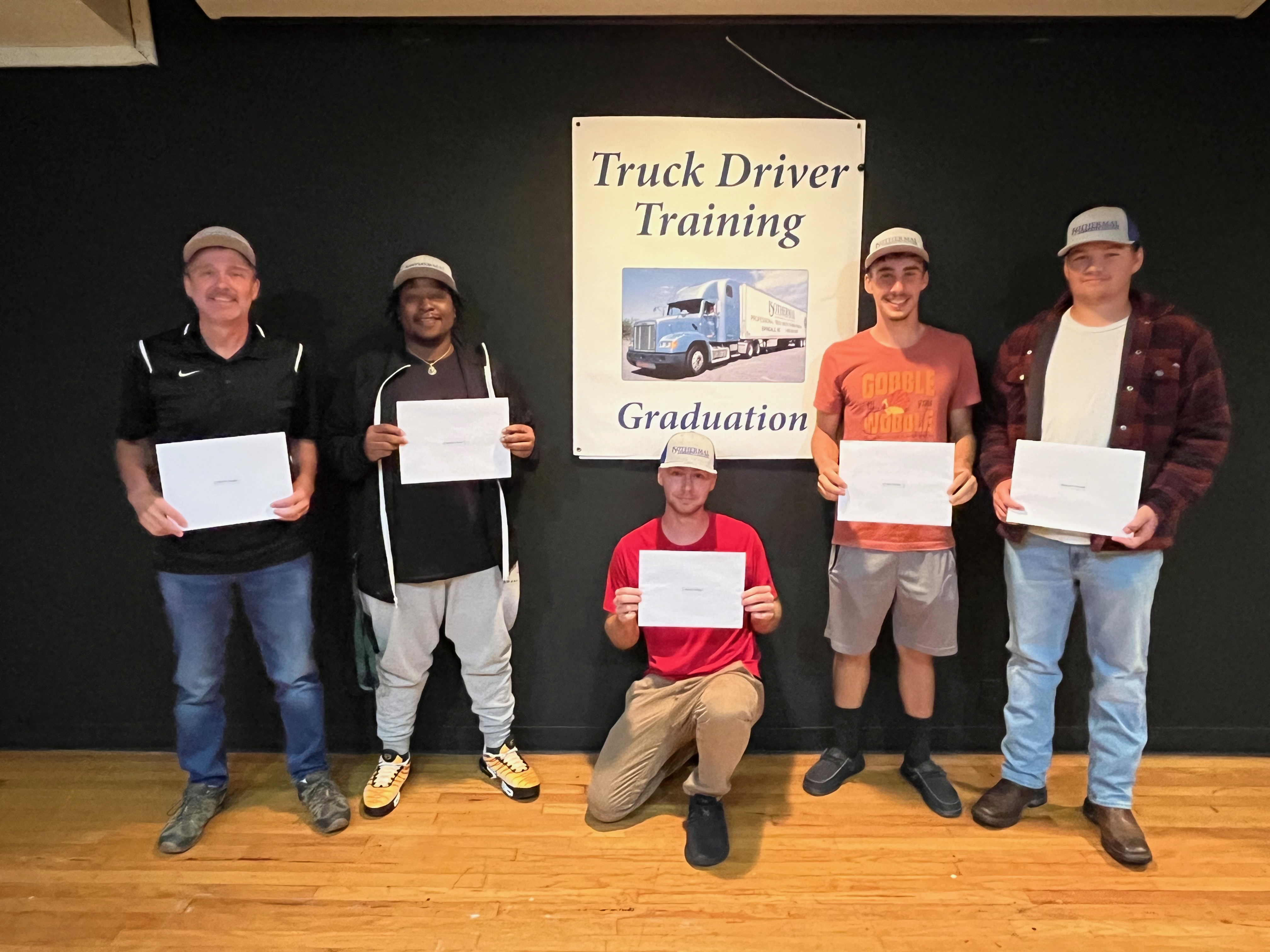 Five ICC students pose holding their certificates at the Truck Driver graduation.