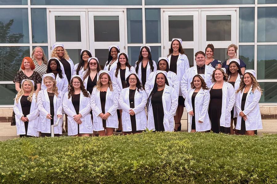 PN Pinning group photo of graduates wearing white coats