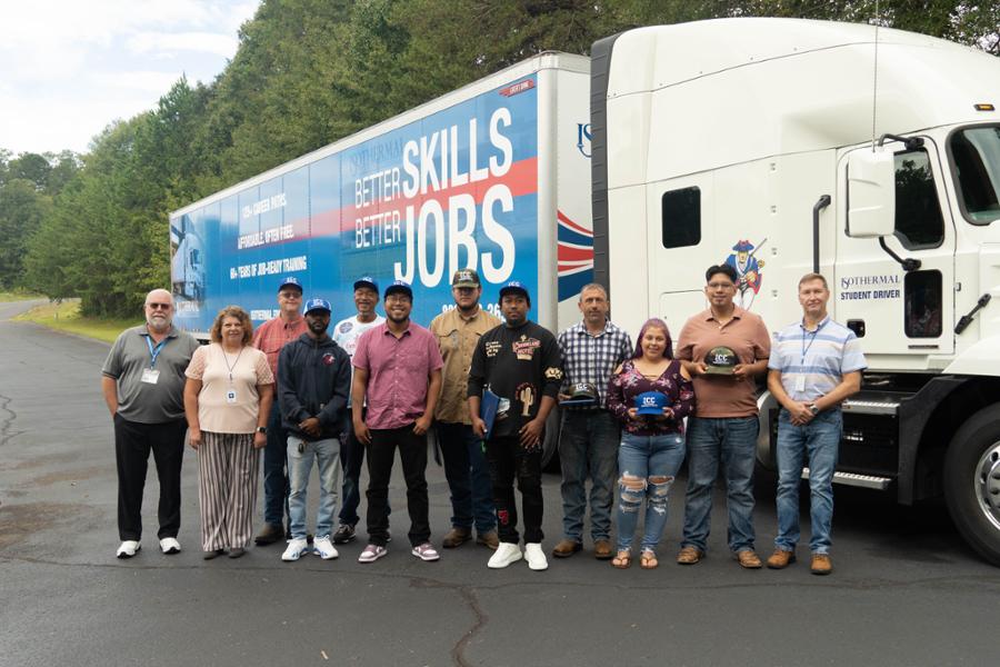 Inaugural graduating class standing in front of the training truck